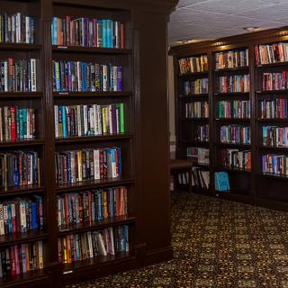 A cozy library interior with wooden bookshelves filled with books.