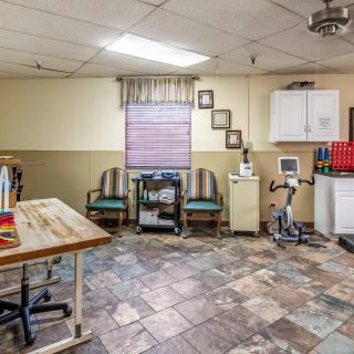 A therapy room equipped with exercise machines and seating area.
