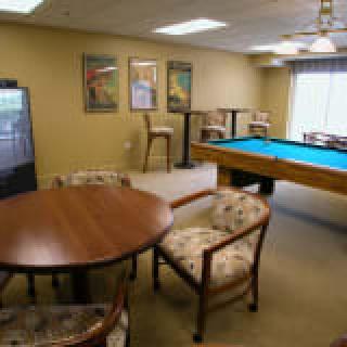 A cozy game room featuring a pool table, seating area, and television.