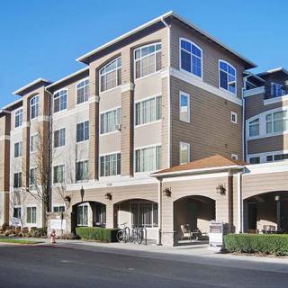 A modern multi-story apartment building with multiple windows and an arched entrance.