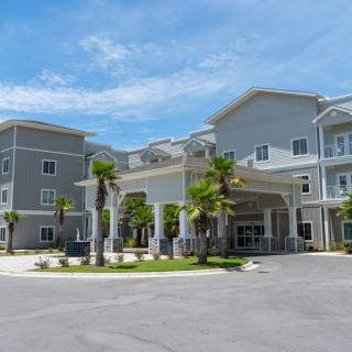 Modern residential building with palm trees at the entrance.