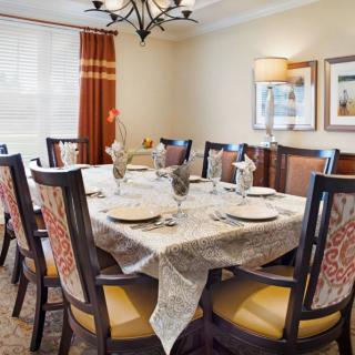 A well-decorated dining room with a set table and elegant chairs.