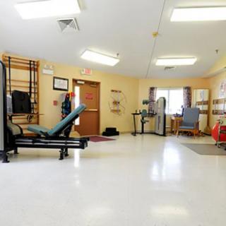 A rehabilitation therapy room equipped with exercise machines and tools.