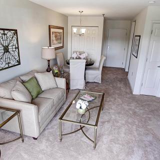 A cozy living room with a connected dining area, featuring elegant furnishings and tasteful decor.