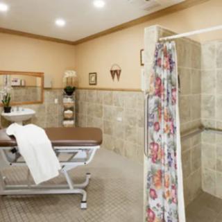 A spa room featuring a therapy table and a shower area with tiled walls, designed for relaxation and rejuvenation.