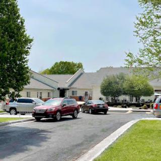 A serene residential neighborhood featuring parked vehicles and well-maintained lawns.