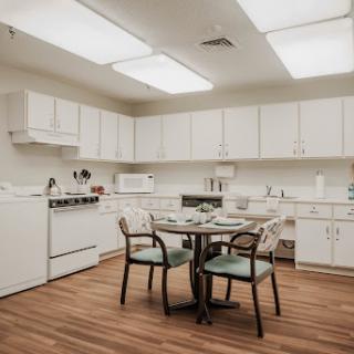 A cozy kitchen featuring a dining table and chairs, equipped with essential appliances.