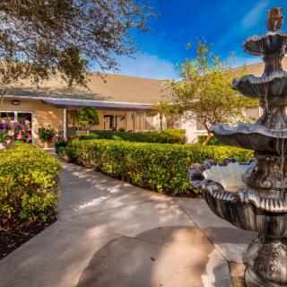 A charming house with a well-maintained garden and a decorative fountain along the pathway.