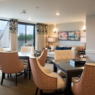 A modern living room and dining area with elegant furniture and ample natural light.