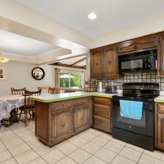 A cozy kitchen with wooden cabinets and a dining area.
