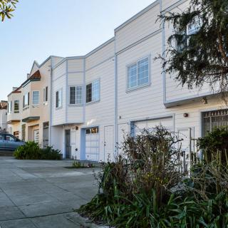 A row of suburban houses with driveways and front gardens.
