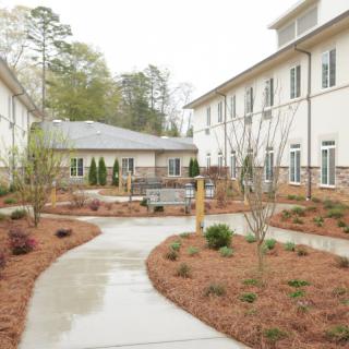 A serene outdoor view of a landscaped garden in between two buildings.