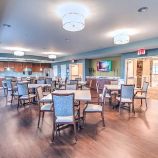 A modern dining area with neatly arranged tables and chairs.
