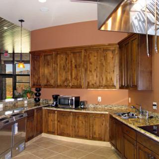A modern kitchen featuring wooden cabinets, stainless steel appliances, and granite countertops.