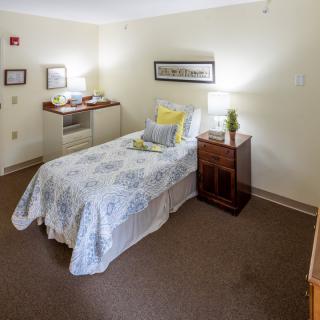 A cozy bedroom with a single bed, nightstand, and decorative elements.