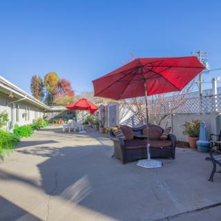 A serene outdoor patio area featuring red umbrellas and comfortable seating, perfect for relaxation.