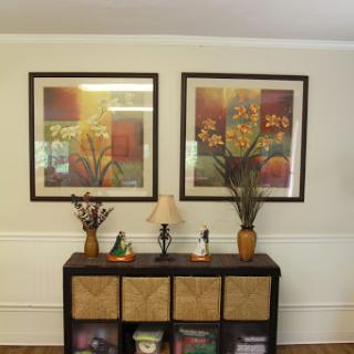 A cozy living space featuring framed artwork and decorative accents on a console table.