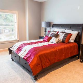 A cozy bedroom with a stylish bed and vibrant bedding.