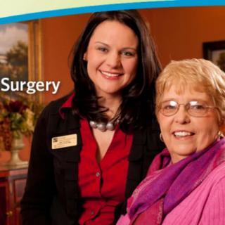 Two women smiling, possibly in a healthcare setting related to surgery.