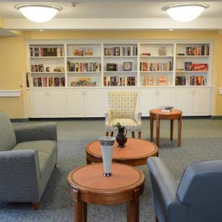 A cozy library reading room with comfortable seating and bookshelves.