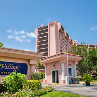 A vibrant hotel entrance featuring modern architecture against a clear blue sky.
