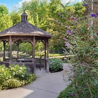 A charming gazebo surrounded by lush greenery in a serene garden setting.