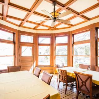 A bright dining area with wooden decor and large windows.