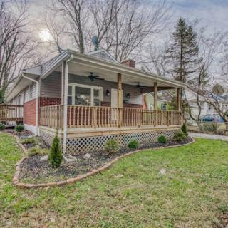 A charming house with a welcoming front porch and landscaped yard.