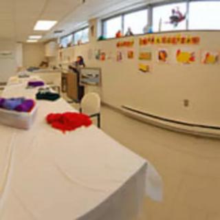 A classroom set up for an art activity, with craft supplies on the table and decorations on the wall.