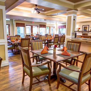 A cozy dining area with neatly arranged tables and chairs, featuring a warm and inviting ambiance.