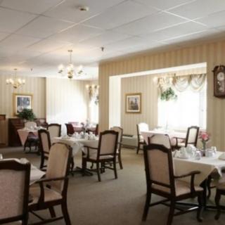 An elegant dining room with neatly arranged tables and chairs, featuring a classic interior design.
