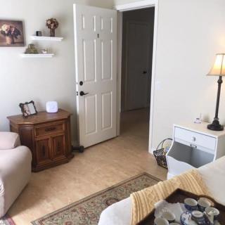 A cozy living room with a sofa, lamp, and open door leading to another room.
