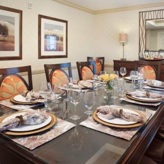 A beautifully set dining table in a formal dining room, featuring elegant place settings and decor.