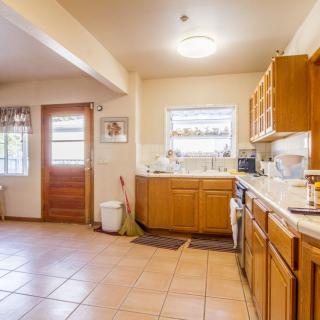A spacious kitchen with wooden cabinets and tiled flooring.