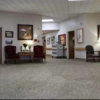A spacious lobby area with chairs, artwork on the walls, and soft lighting.