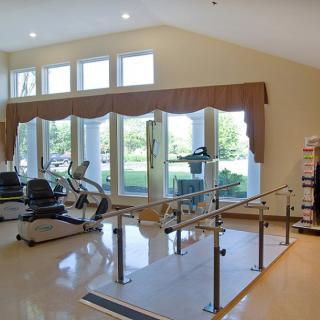 A well-lit rehabilitation center featuring various exercise equipment for physical therapy.