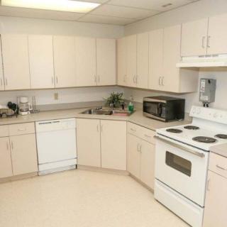 A modern kitchen with white cabinets and appliances.