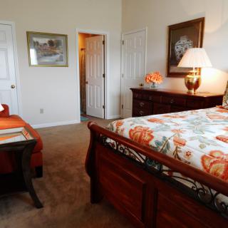 A cozy bedroom with a decorated bed and warm lighting.