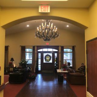 A warm and inviting lobby featuring a stylish chandelier and comfortable seating.