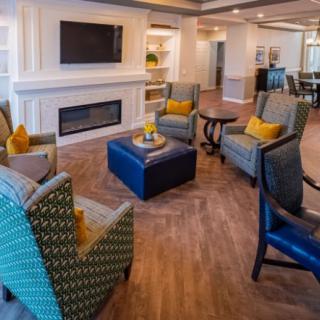 A cozy and modern living room with comfortable seating around a fireplace and TV.
