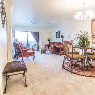 A bright and inviting living room with a dining area, featuring comfortable seating and elegant decor.