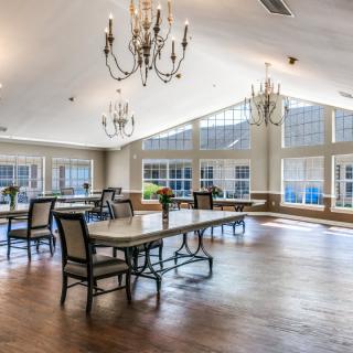 A spacious dining area with large windows and elegant chandeliers.