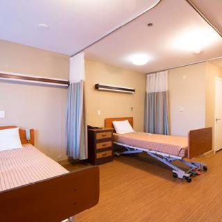 A clean and spacious hospital room with two patient beds.