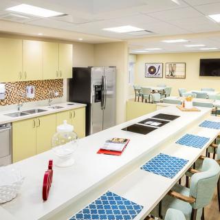 A modern kitchen interior with a long countertop and seating area.