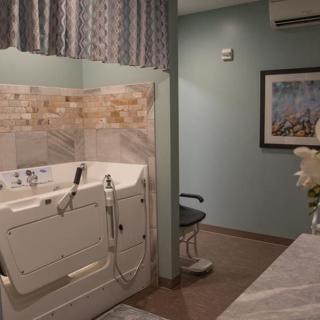A well-designed bathroom featuring an accessible bathtub and a chair for convenience.