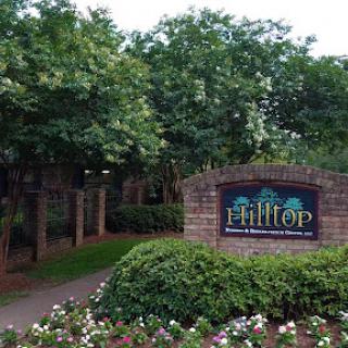 The entrance to Hilltop, surrounded by lush greenery and blooming flowers.