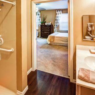 A view from the bathroom into a neat and cozy bedroom, showcasing home interior design.