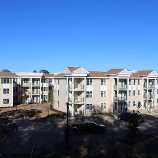 A view of a multi-story apartment building under a clear blue sky.