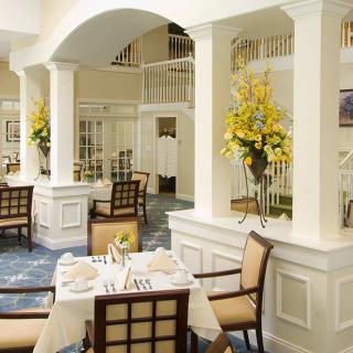 An elegantly designed restaurant dining area with floral decorations and neatly arranged tables.