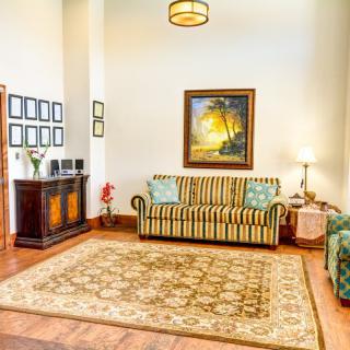A cozy living room featuring a striped couch, decorative rug, and framed artwork, all accentuated by warm lighting.